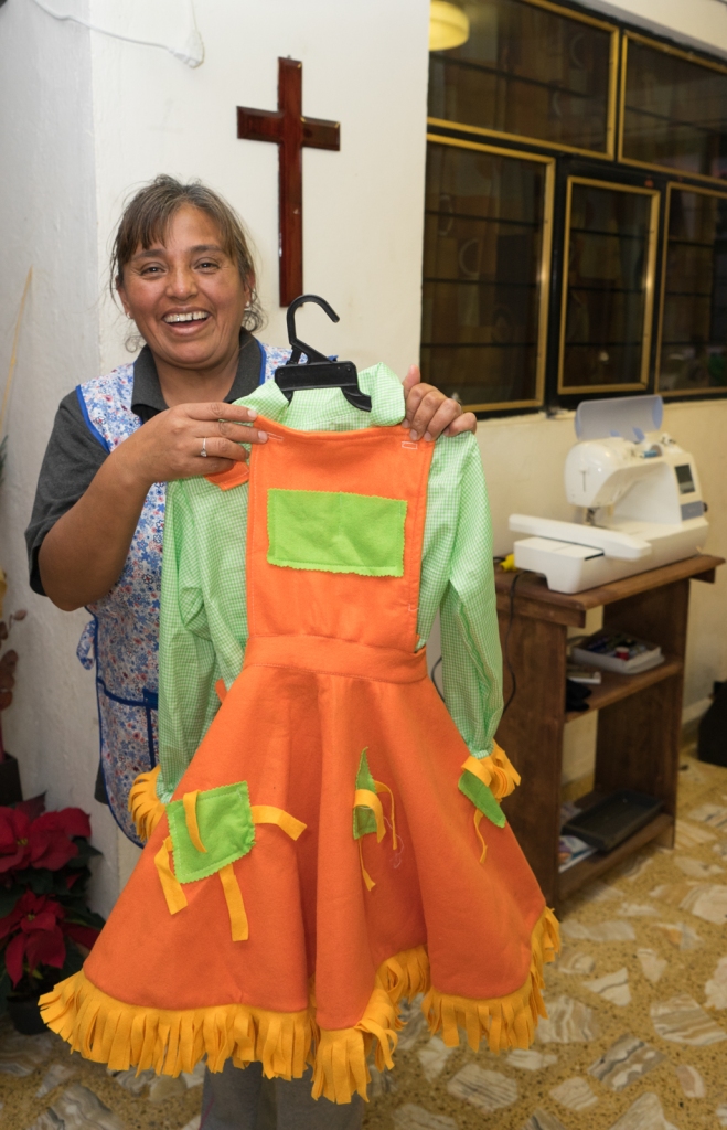 María Elena Neri in her home sewing studio. The orange dress is a costume, but mostly she sews school uniforms.