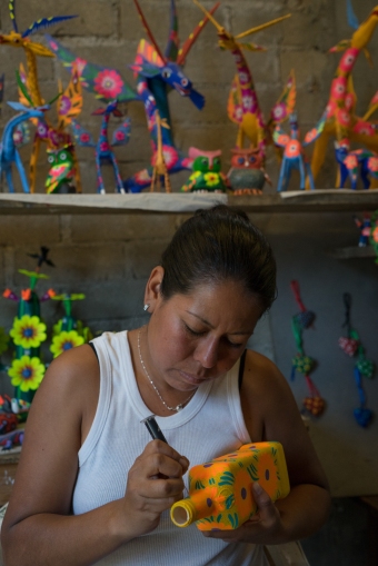 Sisters Isabel Gomez Santiago and Gloria Ines Gomez Santiago paint alebrijes in Arrizola, a small town outside of Oaxaca. This is Isabel using a hypodermic needle to make dots.