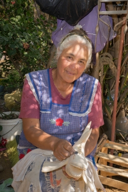 Jesús Jimenez Hernandez makes alebrijes in her home workshop in Arrazola, south of Oaxaca. She sands each carved figure, like the fish in her hands, for about two hours before painting. She's proud that the figures are made from a single piece of wood.